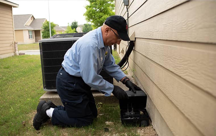 image of an exterminator spraying a house