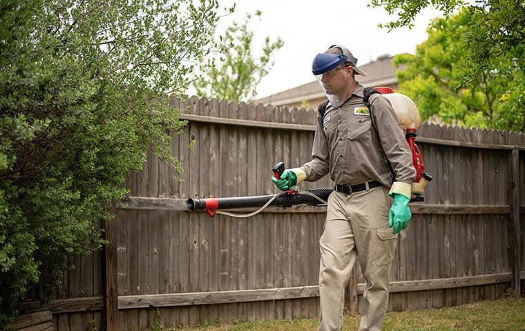 Pest Technician treating backyard